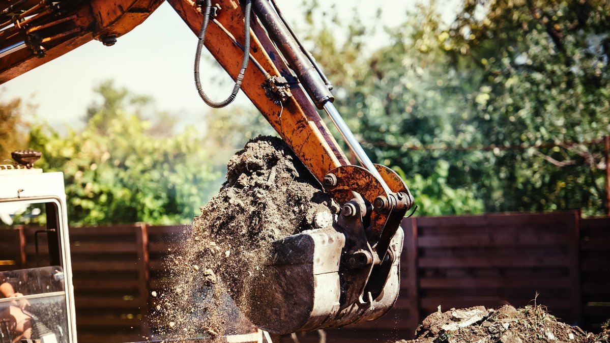 Bagger bewegt Erde auf einer Baustelle als Symbol für nachhaltige Bauplanung und Ressourcennutzung